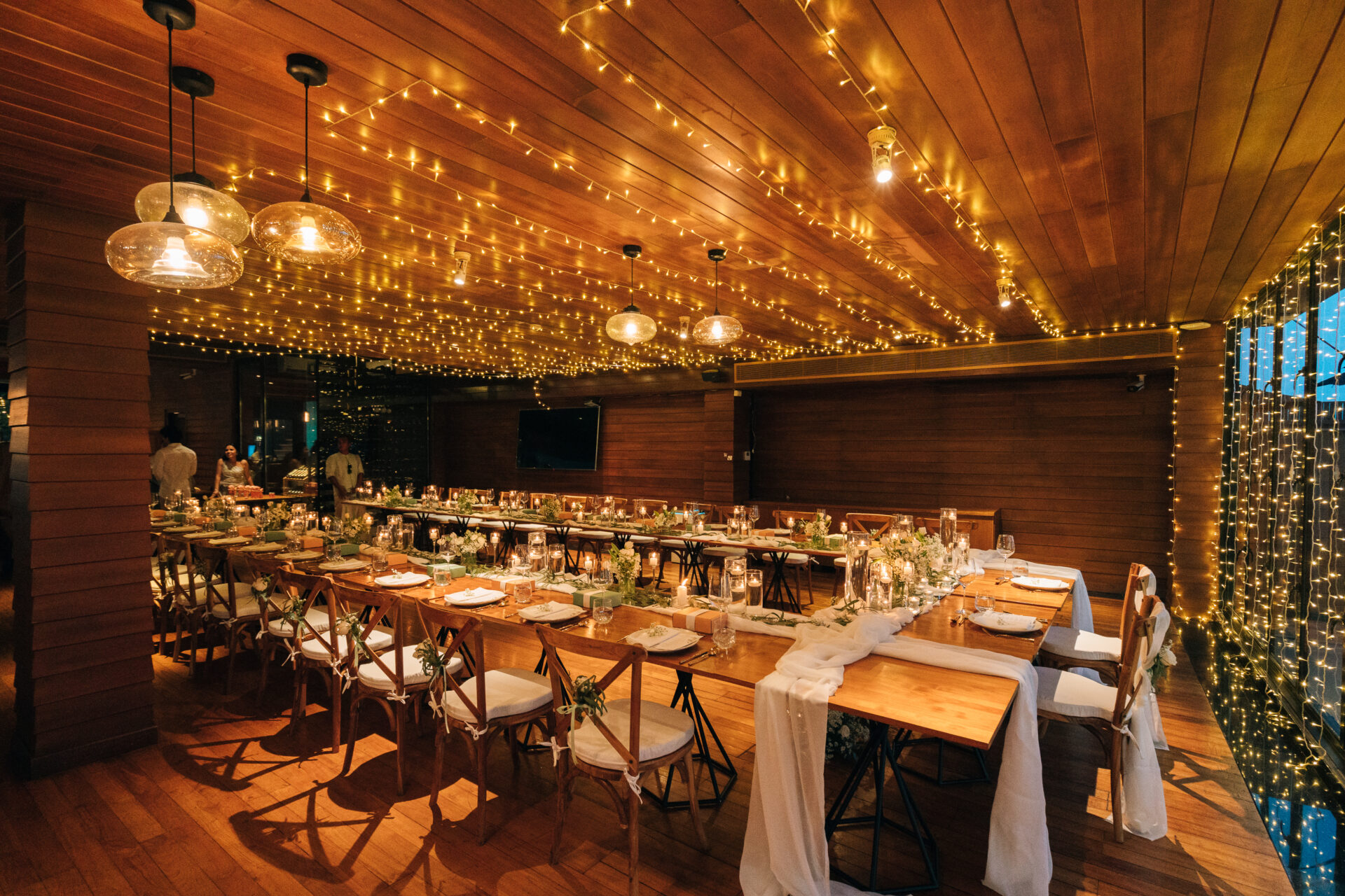 Luxury wedding reception at Silavadee’s "Sun Deck" venue, showing a long banquet table decorated with candles and tropical flowers against a panoramic ocean backdrop.