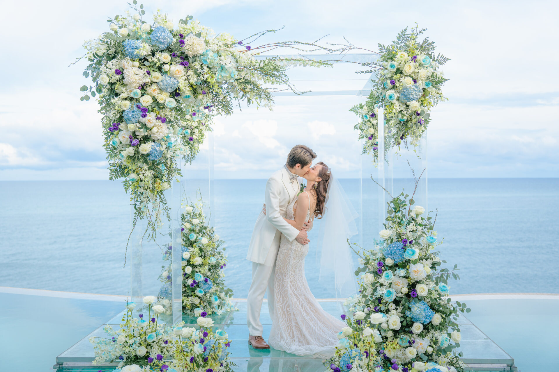 Wedding couple posing on the iconic granite rock formations at Silavadee Pool Spa Resort, with crashing waves and a Koh Samui coastal backdrop.